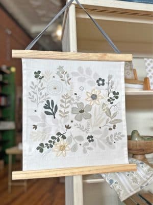 Floral canvas wall hanging with embroidery details, front view.